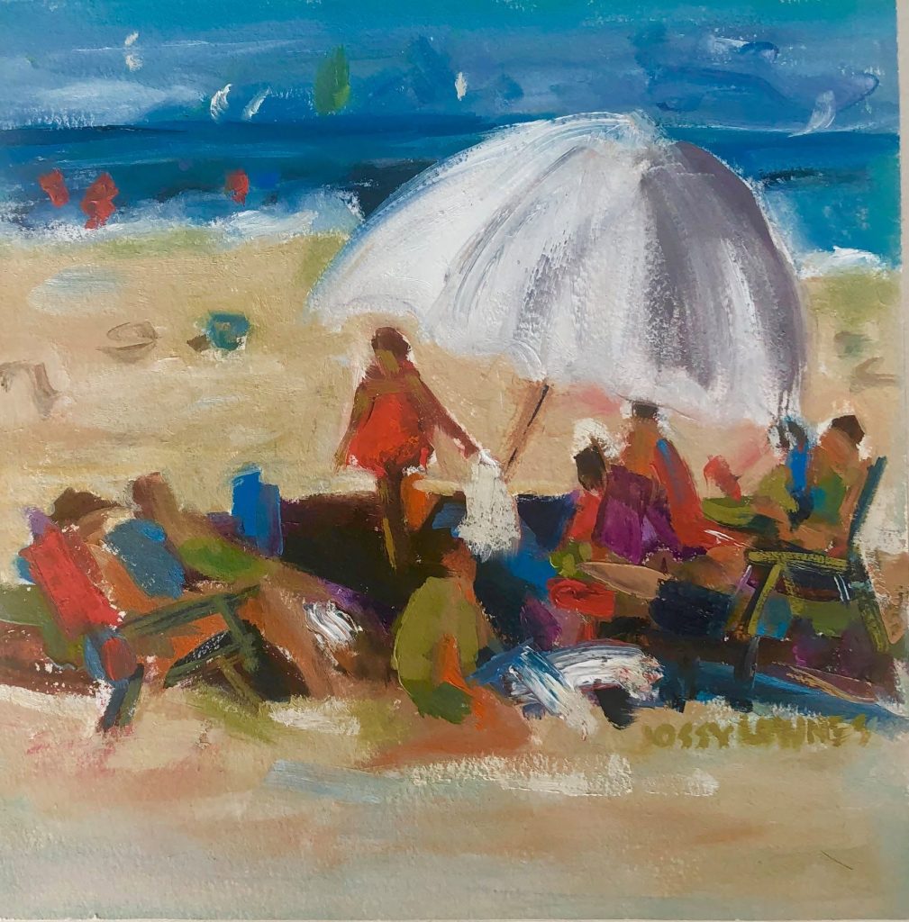 People relax under a large umbrella on the beach, enjoying the sun and ocean view.